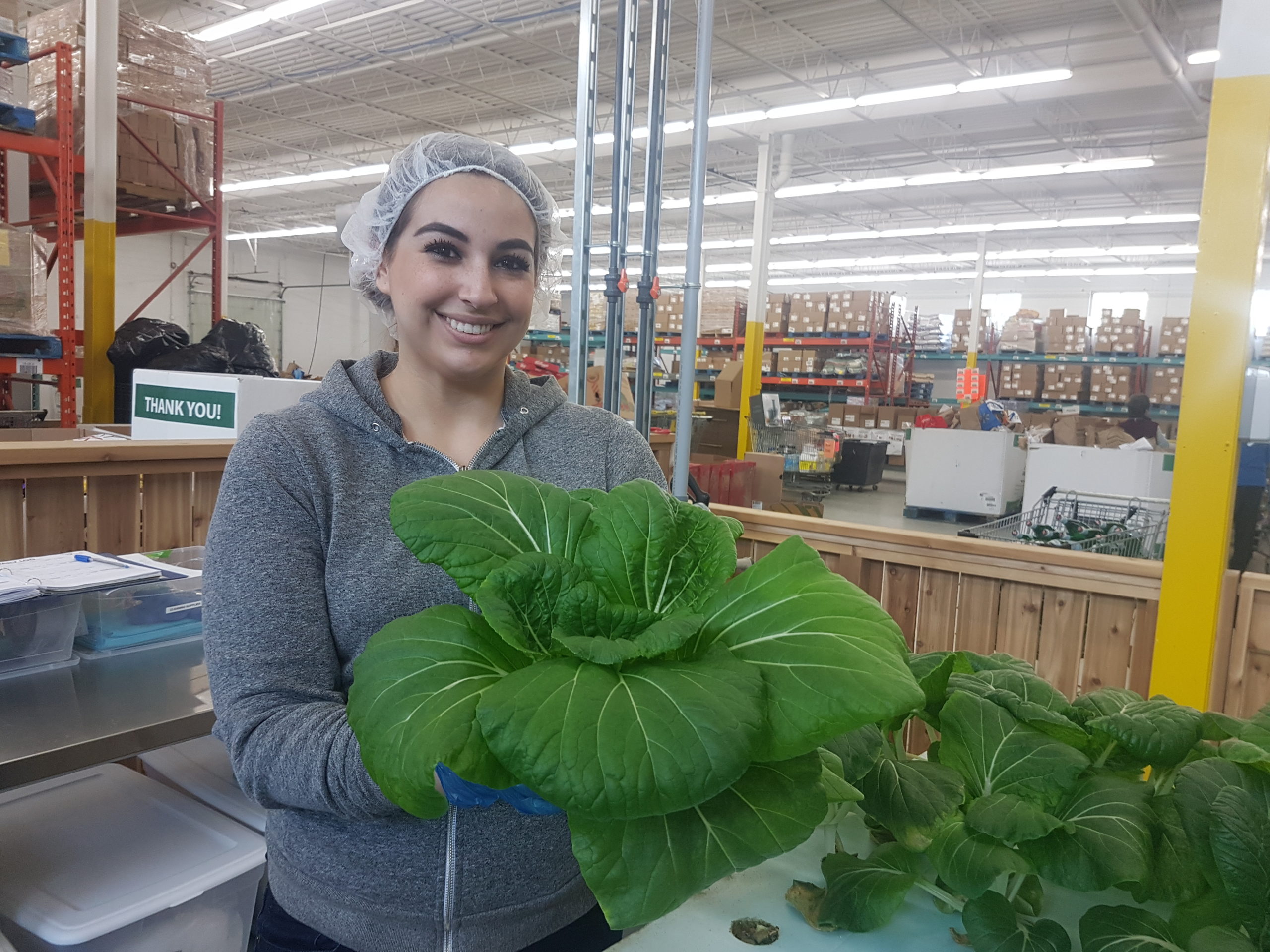women with aquaponic plants in hand